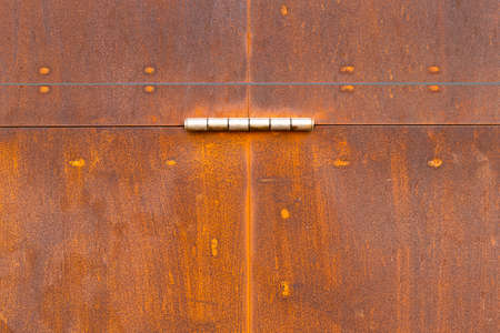 The photo shows a weathered and rusty metal doorの写真素材