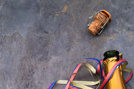 The photo shows the head of an opened champagne bottle with cork on gray backgroundの写真素材