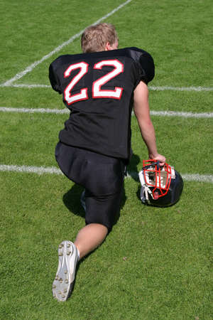 American football player waiting at the sideline for his participation in the gameの写真素材
