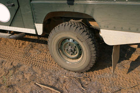 Back tire of a four wheel drive car parking in the bushland in Namibia, Africa
