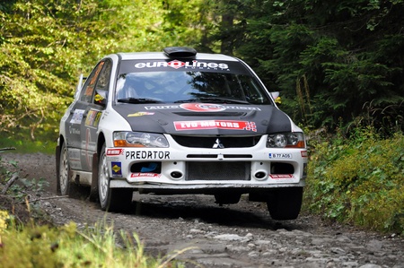 BRASOV, ROMANIA - SEPTEMBER 3 2011: Preda Romulus and his co-driver Baciucu Cristian driving flat-out a Mitsubishi EVO IX at Tara Barsei Rally 2011のeditorial素材