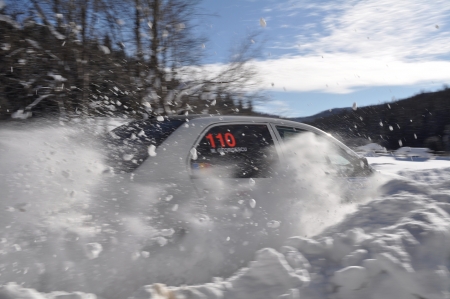 COMANDAU, ROMANIA - JANUARY 28 2012: Catalin Cismaru and his co-driver Nica Daniel through the snow with a Mitsubishi Evo 9 at Comandau Winter Rally 2012のeditorial素材