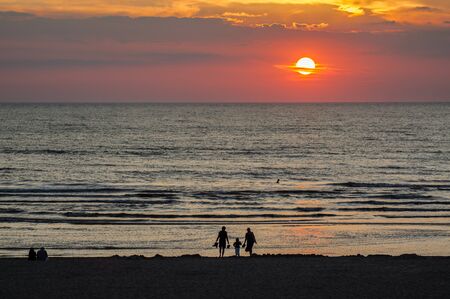 Familiy at the Evening Beach at Sunset Timeの写真素材