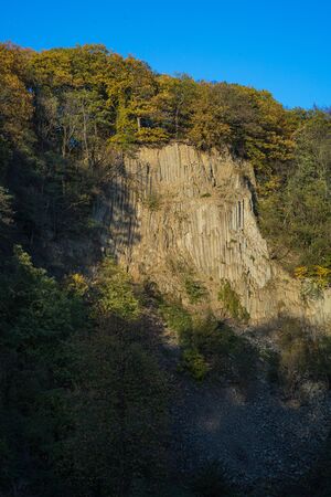 Rock wall at the Weilbergsee with autumn forest in the evening light.の写真素材