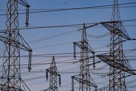 The top of High-voltage pylons against a blue, evening sky.の写真素材