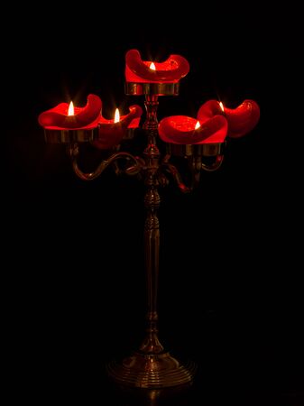 Candelabra with five shining candles on a table.の写真素材