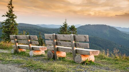 Benches on the Feldberg with a view over hazy hills in the evening.の写真素材