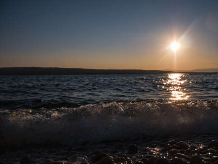 Mysterious view of stones and pebbles in water after sunset in summer.の写真素材