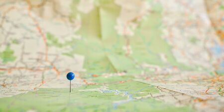 A blue-headed pin marking a place on a map, in closeup.の写真素材