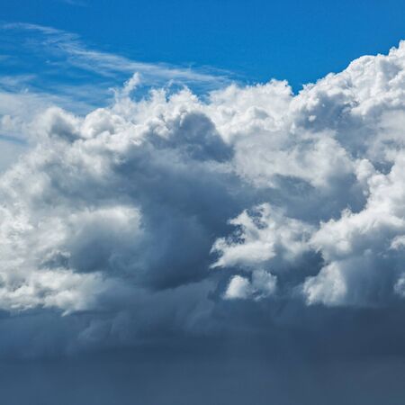 Dark storm clouds approaching with bright blue sky above.