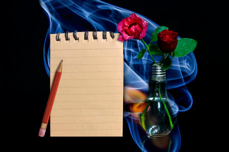 Rose with a notebook on a black background.の写真素材