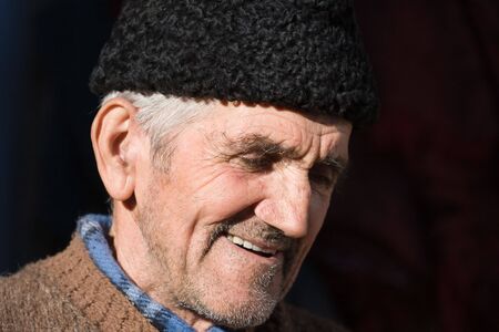 Close-up portrait of a happy senior farmer with black capの写真素材