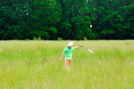 Cute kid playing badminton outdoorsの写真素材