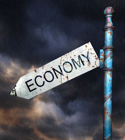 3d Rusted grunge road sign over dramatic sky and rain, concept for economic recessionの写真素材