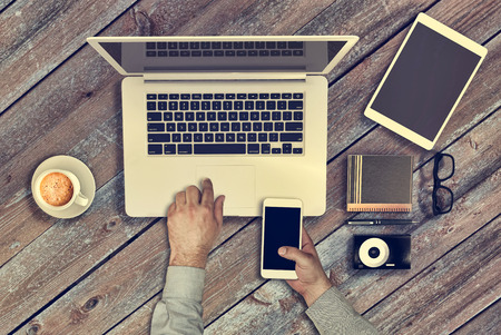 Vintage hipster wooden desktop top view and male hands. Responsive design mockup. Hero header imageの写真素材