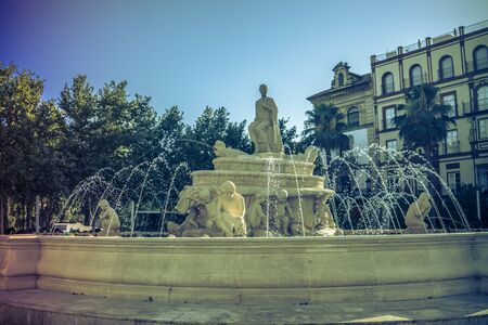 Water fountain with a statue in a main square in Seville, Spain, Europeの写真素材