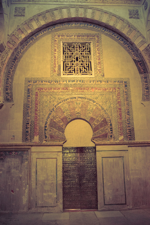 Arabic inscriptions on a wall inside the Mezquita,Mezquita de Córdoba,the Great Mosque of Córdoba, Mosque-Cathedral,La Mezquita, Mezquita in Cordoba, Andalucia with a door and ornate window.の写真素材