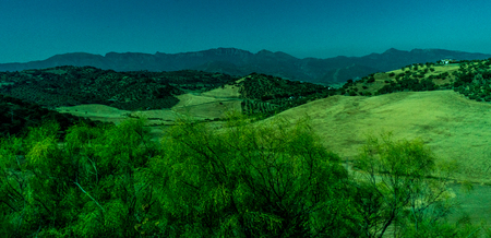 Greenery, Mountains, Farms and Fields on the outskirts of Ronda Spain, Europe on a hot summer day with clear blue skiesの写真素材