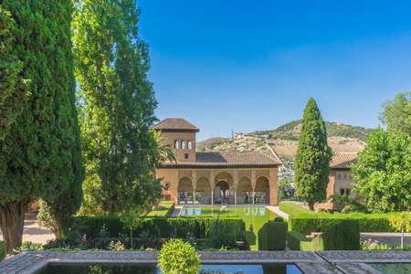 El Partal. A large central pond faces the arched portico behind which stands the Tower of the Ladies, inside the Alhambra of Granada, Andalusia, Spain, Europe on a bright sunny day with clear blue skyのeditorial素材