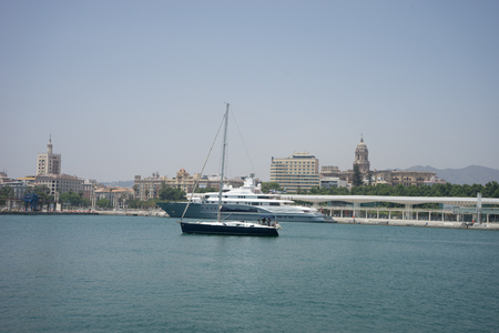 A blue boat sails in the ocean in Malaga, Spain, Europe on a summer dayのeditorial素材