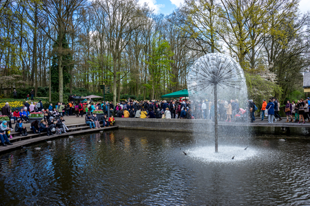 Keukenhoff, Netherlands - April 17 : The Keukenhoff Tulip Gardens on April 17, 2016. Tourists gather near the water fountain  on a summer dayのeditorial素材