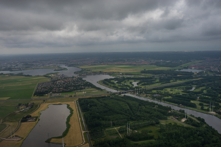 Farms in Holland, Netherlands with canal viewed from plane in sky with clouds viewed from window in aeroplaneの写真素材