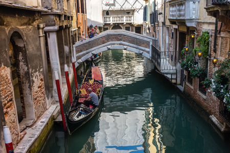 Venice, Italy - 30 June 2018: The gondolas parked with gondolier near bridge in Venice, Italyのeditorial素材