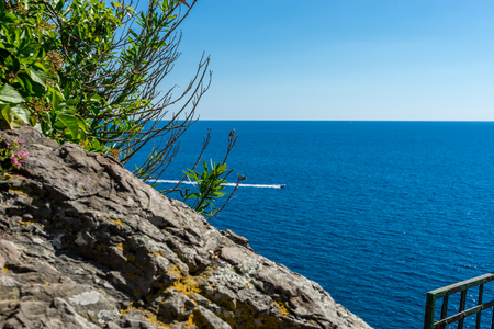 Europe, Italy, Cinque Terre, Vernazza, a close up of a rock next to a body of waterの写真素材