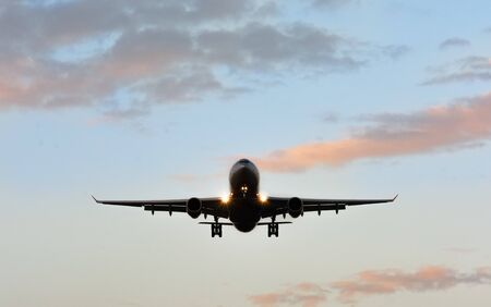 The plane is landing at the sunset. Front viewの写真素材