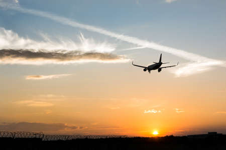 Airplane in the sky. Landing at the sunsetの写真素材
