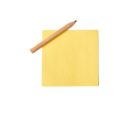Yellow paper note sheet with pencil. Isolated on white backgroundの写真素材