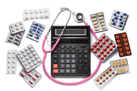 Expensive paid medicine concept. Calculator with stethoscope and various drugs. Isolated on white backgroundの写真素材