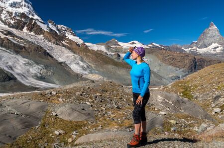 Woman traveler looking at Swiss mountain glacierの写真素材