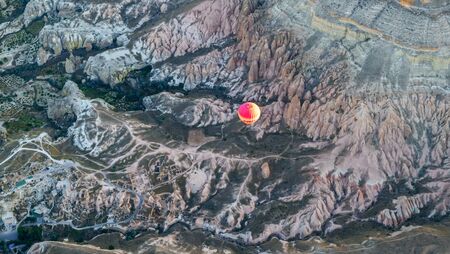 View of the colorful air balloon flying over rock formation and beautiful valley, Cappadocia, Turkeyの写真素材