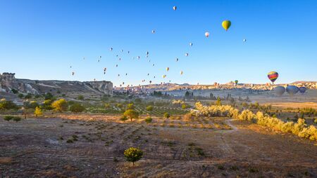 Hot air balloon flying over rock landscape at Cappadocia Turkeyの写真素材