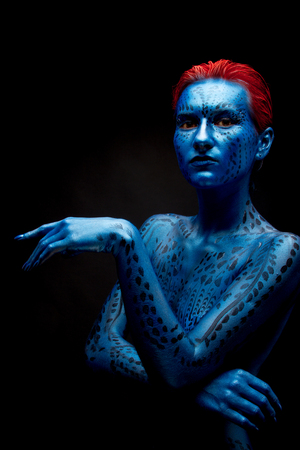 The girl with blue skin and red hair on a black background.の写真素材