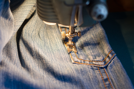 Sewing jeans on the sewing machine.の写真素材