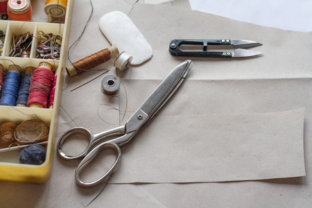 Sewing supplies - the attributes of the master. On the desktop lay a pair of scissors, a box of...