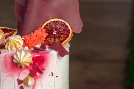 Beautiful tiered birthday cake on a dark wooden background.の写真素材