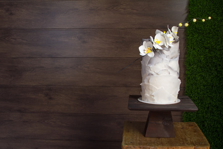 Beautiful tiered birthday cake on a dark wooden background.の写真素材