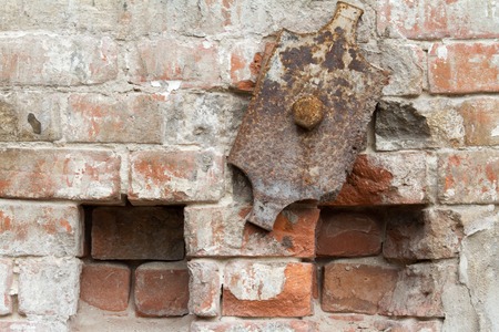 Vintage background texture of old brick masonry on ancient cement with cracks with traces of old paint.の写真素材