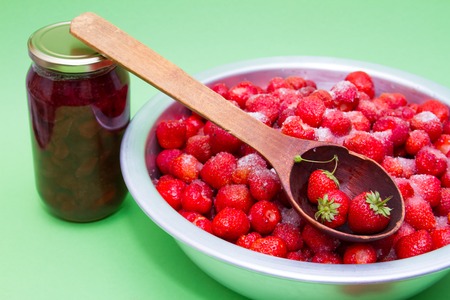 Strawberries in a manufacturer with sugar and jars for making jam.の写真素材