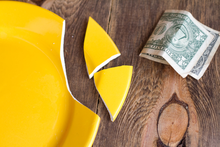 Broken plate and money.の写真素材