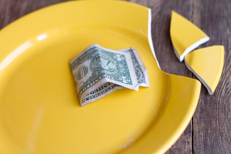 Broken plate and money.の写真素材