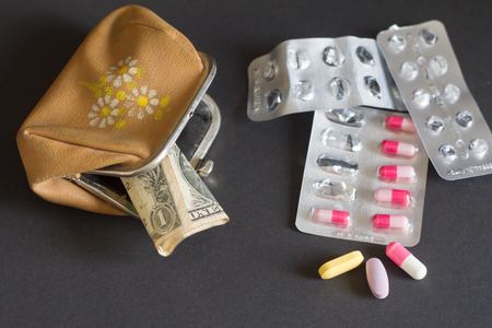 Pills with an empty leather wallet on dark background.の写真素材