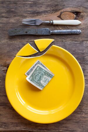 Broken plate and money.の写真素材