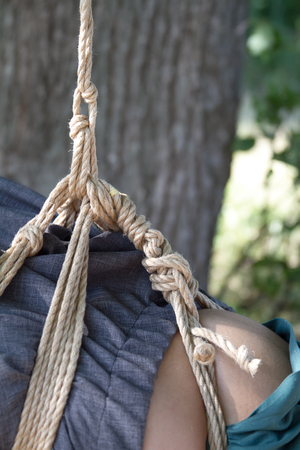 Shibari in nature in summer. Bound young girl.の写真素材