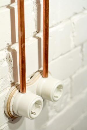 A vintage outlet and electrical wiring in a copper tube.の写真素材