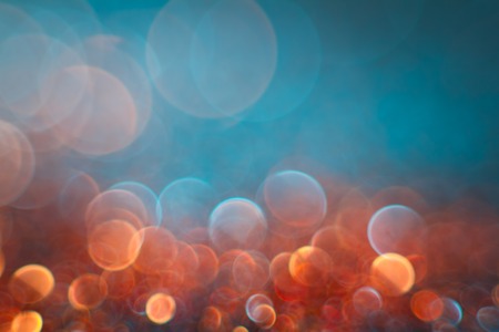 Abstraction orange bokeh on a blue background. Defocused.の写真素材