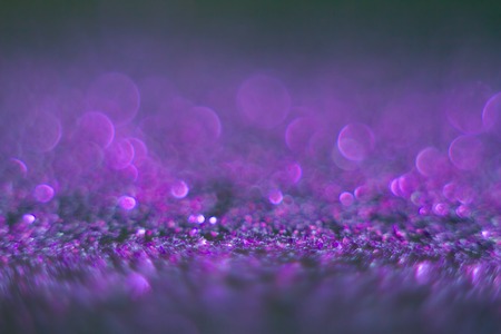 Violet bokeh on a black background. Defocused. Abstract background for your design. Free space for...
